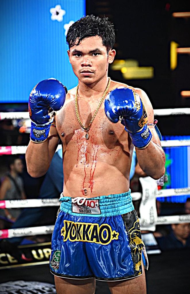 นักชกมุมน้ำเงิน โล่ห์ทอง กรวยในเมืองยิมส์ โล่ห์ทอง กรวยในเมืองยิมส์